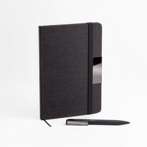 Bloco A5 com capa rígida de tecido RPET, adornado com um elegante detalhe metálico, ideal para gravação a laser